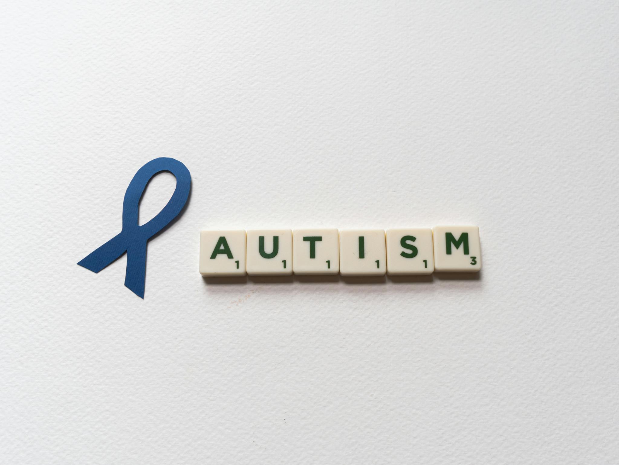 Blue Ribbon And Autism Spelled With Letter