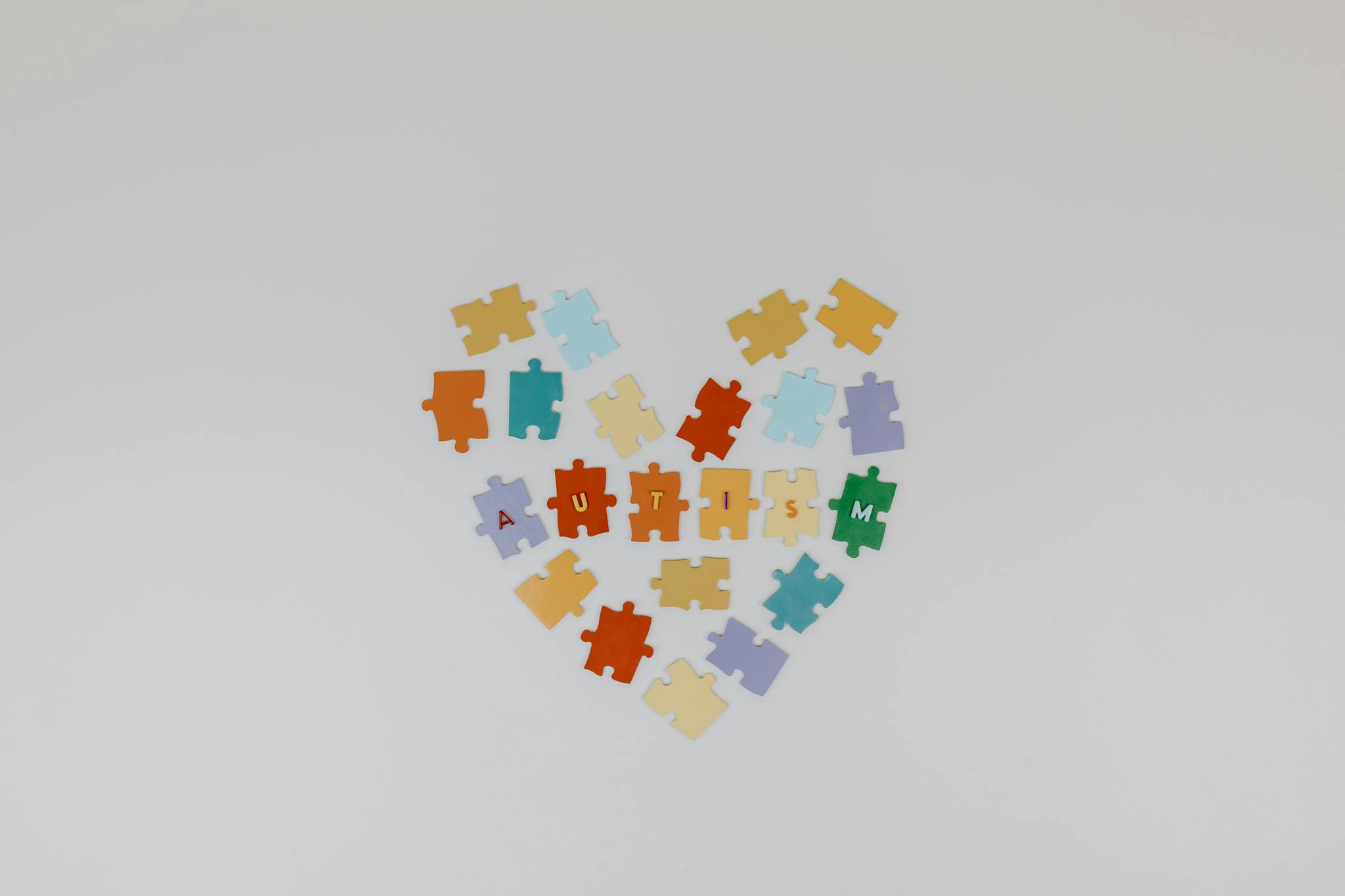 Puzzle pieces forming a heart shape with 'Autism' text, symbolizing autism awareness.